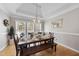 Formal dining room with stylish chandelier, tray ceilings, and large windows at 6 Kersey Ct, Durham, NC 27713