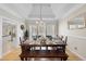Formal dining room with tray ceiling, hardwood floors, and view to adjacent kitchen at 6 Kersey Ct, Durham, NC 27713