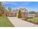 A brick and siding home boasts a well-manicured lawn and driveway with basketball hoop at 6 Kersey Ct, Durham, NC 27713