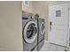 Bright laundry room features a modern washer and dryer set, next to a white door with a light-colored floor at 6 Kersey Ct, Durham, NC 27713