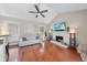 Cozy living room featuring a fireplace, ceiling fan, hardwood floors, and natural light from multiple windows at 6 Kersey Ct, Durham, NC 27713