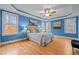 Luxurious bedroom showcasing blue walls, hardwood floors, and a tray ceiling with a fan at 66 Windsong Dr, Pittsboro, NC 27312