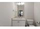 Well-lit half bathroom features a modern vanity with a quartz countertop, toilet, and a large mirror at 712 E Edenton St # 102, Raleigh, NC 27601