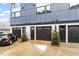 Three dark garage doors on a modern house with small trees planted in front, with a mini cooper parked on the driveway at 712 E Edenton St # 102, Raleigh, NC 27601