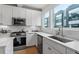 Modern kitchen featuring white cabinets, stainless steel appliances, quartz countertops and great natural light at 712 E Edenton St # 102, Raleigh, NC 27601