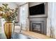 Cozy living room features a fireplace, modern TV and decor, and lots of natural light at 7128 Trappers Ct, Zebulon, NC 27597