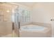 Bathroom featuring a tiled corner tub and glass-enclosed shower at 9510 Dellbrook Ct, Raleigh, NC 27617