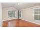 Bedroom with wood floors, neutral walls, and multiple windows offering natural light at 9510 Dellbrook Ct, Raleigh, NC 27617