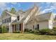 View of the exterior of the home featuring brick accents, mature landscaping, and a manicured lawn at 9510 Dellbrook Ct, Raleigh, NC 27617