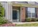 Close up of the front door showing brick accents, and manicured landscaping at 9510 Dellbrook Ct, Raleigh, NC 27617