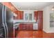 Modern kitchen with granite countertops, stainless steel appliances, and cherry cabinets at 9510 Dellbrook Ct, Raleigh, NC 27617