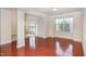 Sunlit living room featuring gleaming hardwood floors, large windows, and neutral decor at 9510 Dellbrook Ct, Raleigh, NC 27617
