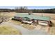 Aerial view of the property with a brick home, outbuildings and large grassy area at 9550 Silk Hope Liberty Rd, Siler City, NC 27344
