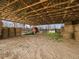 Barn interior with hay bales and farm equipment at 9550 Silk Hope Liberty Rd, Siler City, NC 27344