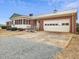 Side exterior view showing the garage and entrance of the brick home with a spacious driveway at 9550 Silk Hope Liberty Rd, Siler City, NC 27344