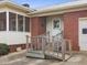 Close-up of the front entrance of the brick home, featuring a ramp and screen door porch at 9550 Silk Hope Liberty Rd, Siler City, NC 27344
