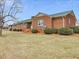 Beautiful brick home with a green roof, showcasing a well-manicured lawn and landscaping at 9550 Silk Hope Liberty Rd, Siler City, NC 27344