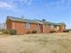 Well-maintained brick home featuring a green metal roof and neatly trimmed shrubs at 9550 Silk Hope Liberty Rd, Siler City, NC 27344
