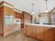 Large kitchen with wood cabinets, eat-in counter and view into brick fireplace at 9550 Silk Hope Liberty Rd, Siler City, NC 27344