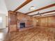 Spacious living room features a brick fireplace, wood paneling, wood beams and hardwood floors at 9550 Silk Hope Liberty Rd, Siler City, NC 27344