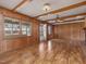 Bright living room featuring wood paneling, wood beams, hardwood floors and plenty of natural light at 9550 Silk Hope Liberty Rd, Siler City, NC 27344