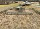 Aerial view of the property showing livestock railing area and shelter in large open field at 9550 Silk Hope Liberty Rd, Siler City, NC 27344