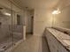 Bright primary bathroom featuring a walk-in shower, double vanity, and tile flooring at 10420 Sablewood Drive Dr # 102, Raleigh, NC 27617