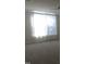 Bright bedroom featuring a large window with sheer white curtains and light colored carpet at 10420 Sablewood Drive Dr # 102, Raleigh, NC 27617