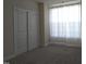 Bedroom featuring sliding door closet, sheer white curtains and light colored carpet at 10420 Sablewood Drive Dr # 102, Raleigh, NC 27617