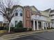Beautiful townhouse with a red brick facade, white columns, and an open balcony at 10420 Sablewood Drive Dr # 102, Raleigh, NC 27617