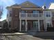 Stunning townhouse with a brick facade, a balcony with white railings, and well-maintained landscaping at 10420 Sablewood Drive Dr # 102, Raleigh, NC 27617