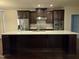A kitchen with stainless steel appliances, dark cabinets, a granite backsplash and a large island at 10420 Sablewood Drive Dr # 102, Raleigh, NC 27617