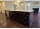 A dark-wood kitchen island featuring drawers, cabinets, a stainless steel dishwasher, and granite countertop at 10420 Sablewood Drive Dr # 102, Raleigh, NC 27617