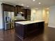 A modern kitchen features stainless steel appliances, dark wood cabinets, and an expansive kitchen island at 10420 Sablewood Drive Dr # 102, Raleigh, NC 27617