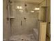 Updated tiled walk-in shower featuring a built-in bench and dual shower heads at 10420 Sablewood Drive Dr # 102, Raleigh, NC 27617