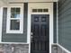 Elegant front door with sidelight and stone accents, showcasing the home's curb appeal at 116 Willow Cameron Way, Angier, NC 27501