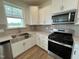 Stylish kitchen featuring a stainless steel farmhouse sink, stainless appliances and grey subway tile backsplash at 116 Willow Cameron Way, Angier, NC 27501
