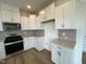 Modern kitchen with white cabinets, stainless steel appliances, and ample counter space, ideal for cooking and storage at 116 Willow Cameron Way, Angier, NC 27501