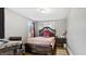 Bedroom featuring a decorative headboard, neutral walls, wood floors, and a view of the outdoors at 121 Hamilton St, Henderson, NC 27536