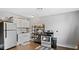 Well-lit kitchen featuring white cabinetry, modern appliances, and an oven with a black range hood at 121 Hamilton St, Henderson, NC 27536