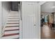 Staircase in a home with white stairs with a carpet runner, a closet, and a view of the living room at 121 Hamilton St, Henderson, NC 27536