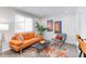 Bright living room with a comfortable orange sofa, modern decor, and a large window at 1309 Hudson Ave # D8, Durham, NC 27705