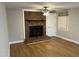 Living room featuring hardwood floors, brick fireplace, ceiling fan, and neutral wall colors at 1600 Buffaloe Rd, Garner, NC 27529