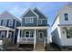 Inviting two-story home with light blue siding, white trim, and a charming front porch with classic white railings at 1905 Plott Balsam Dr, Wendell, NC 27591