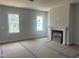 Spacious, unfinished living room with abundant natural light, fireplace, and access to outdoor views at 1905 Plott Balsam Dr, Wendell, NC 27591