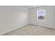 Empty bedroom features neutral carpet, white walls, base molding, and a window offering natural light at 2117 Trailside Dr, Durham, NC 27704