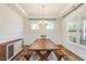 Bright dining room with tray ceiling, large windows, and a rustic wooden table with bench seating at 220 Green Haven Blvd, Youngsville, NC 27596