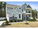 Charming two-story home with gray siding, stone accents, covered porch, balcony, and attached garage at 220 Green Haven Blvd, Youngsville, NC 27596
