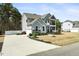 Two-story home with gray siding, stone accents, covered porch, balcony, and a spacious driveway at 220 Green Haven Blvd, Youngsville, NC 27596