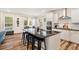 Bright kitchen with a large island, modern lighting, stainless steel appliances, and a view to the backyard at 220 Green Haven Blvd, Youngsville, NC 27596